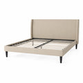 Cama tapizada beige con somier de listones metálicos y patas de madera